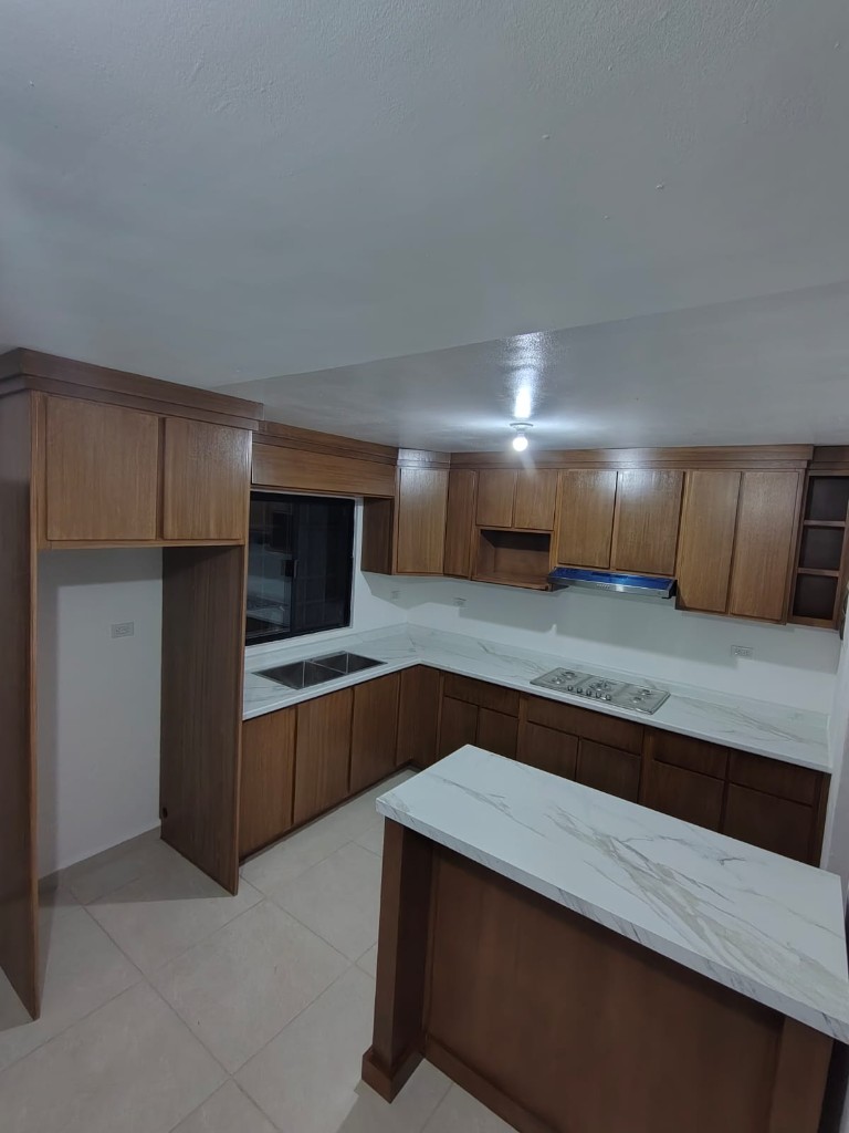 Cocina en tono madera con cubierta clara e isla, proyecto entregado